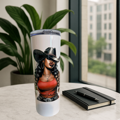 Tumbler with a design of a woman wearing a cowboy hat on a table with a notebook and pen.