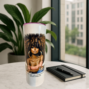 Tumbler with a design of a woman with styled hair on a table with a notebook and pen.