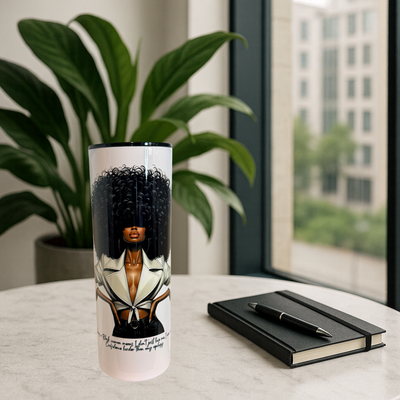Tumbler with a design of a woman with an afro on a table with a plant and notebook in the background.
