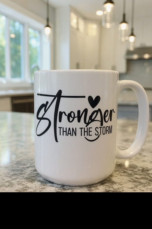 White mug with 'Stronger Than The Storm' text on a kitchen counter